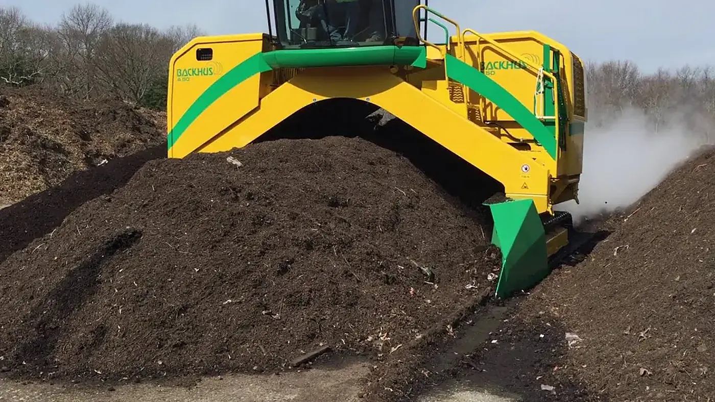 Machine turning a heap of soil during biological soil remediation